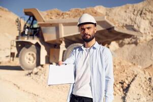 Document to fulfill. Man ,in uniform is working in the quarry at daytime photo
