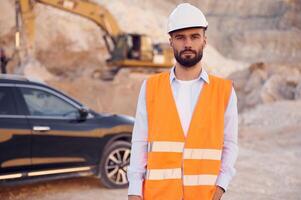 Posing for, a camera. Man in uniform is working in the quarry at daytime photo