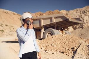 Business conversation by phone. Man in uniform is,working in the quarry at daytime photo