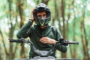 With safety helmet. .TV driver is in the forest, having a ride at daytime photo