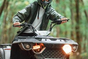 Front view. ATV, driver is in the forest, having a ride at daytime photo