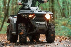 Front ,view. ATV driver ,is in the forest, having a ride at daytime photo