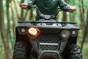 Front ,view. ATV, driver is in the forest, having a ride at daytime photo