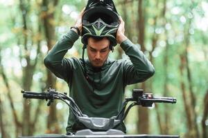 With, safety helmet. TV driver is in the forest, having a ride at daytime photo