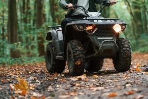 Front view. ATV driver is ,in the forest, having a ride at daytime photo