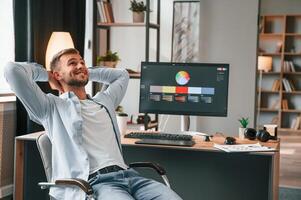 Designer is, sitting by ,the computer and using graphics tablet with stylus photo