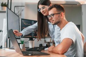Analyzing information ,from computer screens. Two stock brokers is working together in the office with finances photo