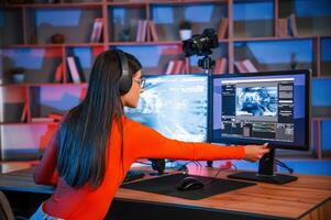 Setting up the monitor angle of view. Young beautiful game streamer is indoors with pc photo