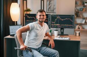 Young stock, broker is working in the office by using computer photo