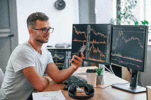 Young stock broker is working in the office by using computer photo