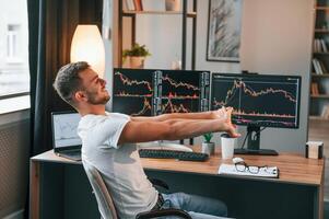 Taking a break. Young, stock broker ,is working in the office by using computer photo