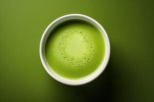 A bowl of green tea on a green background photo