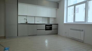 A builder in uniform washes the floor in a new apartment. The concept of construction and repair. video