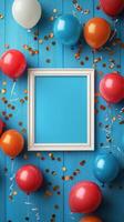 Colorful party decorations with balloons and a blank frame on a blue wooden background for celebrations and events photo