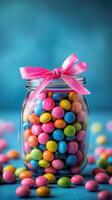 Colorful candy jar filled with vibrant sweets and surrounded by scattered candies on a blue background photo