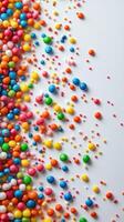 Colorful variety of candy balls scattered on white surface creates a vibrant visual display in an artistic arrangement photo