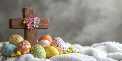 Colorful Easter eggs arranged around a wooden cross with flowers on a soft texture background photo
