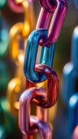 Close-up view of vibrant metal chains in various colors illuminated by sunlight photo