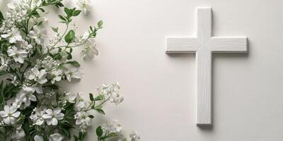 White wooden cross adorned with delicate white flowers in a serene arrangement for peaceful reflection photo