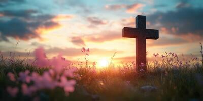 Sunset behind a cross in a tranquil field adorned with blooming flowers photo