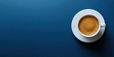 Freshly brewed coffee served in a white cup on a smooth blue table surface in a cozy setting photo
