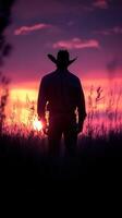 Cowboy silhouette against a vibrant sunset in the open fields during evening hours photo