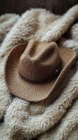 Brown cowboy hat resting on a cozy wool blanket in a rustic setting photo