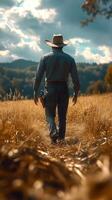 Cowboy walking through golden grasslands under a dramatic sky in a serene countryside setting photo