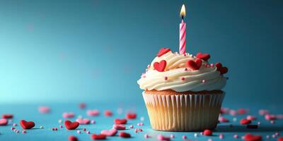 Delicious cupcake with heart-shaped decorations and a lit candle on a blue backdrop for a festive celebration photo