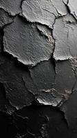Textured black surface with cracked paint highlighting patterns and details in natural lighting photo