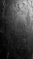 Dark textured surface with a rough finish creating an abstract background ideal for design projects and artistic expressions photo
