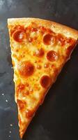 Deliciously cheesy pepperoni pizza slice on a black surface ready to enjoy photo