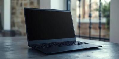 Sleek black laptop resting on modern table in bright room with large windows in afternoon light photo