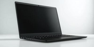 Sleek black laptop positioned on a minimalist white desk, ready for use in a modern workspace photo