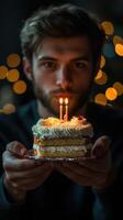 Person celebrating birthday with cake and candles in a cozy setting during evening light photo