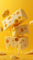 Cheese blocks suspended in mid-air above a vibrant yellow backdrop with melting edges photo