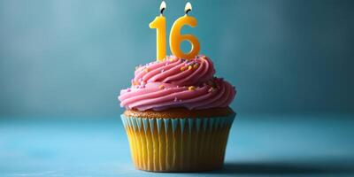 Celebrating a sweet sixteen with a colorful cupcake topped with vibrant frosting and birthday candles photo