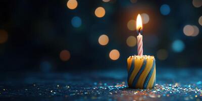 Colorful birthday candle burns brightly on festive table surrounded by sparkling lights photo