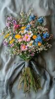 Colorful wildflower bouquet arranged elegantly with a soft gray background in serene lighting photo