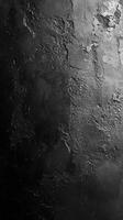 Textured black surface with rough patches creates a bold artistic backdrop for creative designs and compositions photo