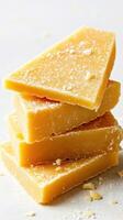 Stack of homemade yellow soap on a light surface with shavings scattered around, showcasing a rustic aesthetic and artisanal qualities photo