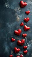 Decorative red hearts create a vibrant pattern against a dark textured background, perfect for romantic celebrations or special occasions photo