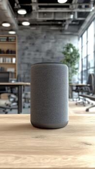 Modern smart speaker positioned on a wooden table in a contemporary office workspace designed for productivity photo