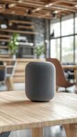 Modern smart speaker placed on a wooden table in a stylish office environment promoting a contemporary work atmosphere photo