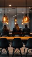 Modern workspace features warm lighting and professionals engaged in discussion during a corporate meeting photo