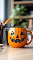 Festive pumpkin-shaped mug on a table amid workspace with stationery and plant decorations photo