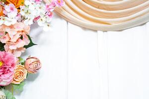 Elegant flower arrangement on white wooden background with fabric drape romantic wedding backdrop. photo