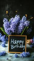 Bright purple flowers in a vase with a birthday greeting in a cozy, festive indoor setting photo