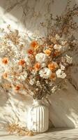 Beautiful arrangement of dried flowers in a white vase against a marbled background photo