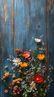 Vibrant wildflowers arranged against a rustic blue wooden backdrop in a bright and cheerful display photo